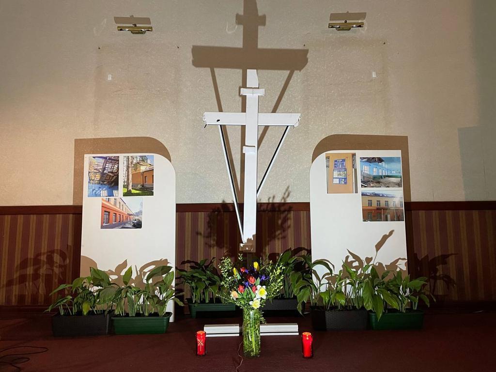 Chemin de croix à Lviv: prier devant la croix réalisée avec le montant de fenêtre d'une école bombardée à Irpin